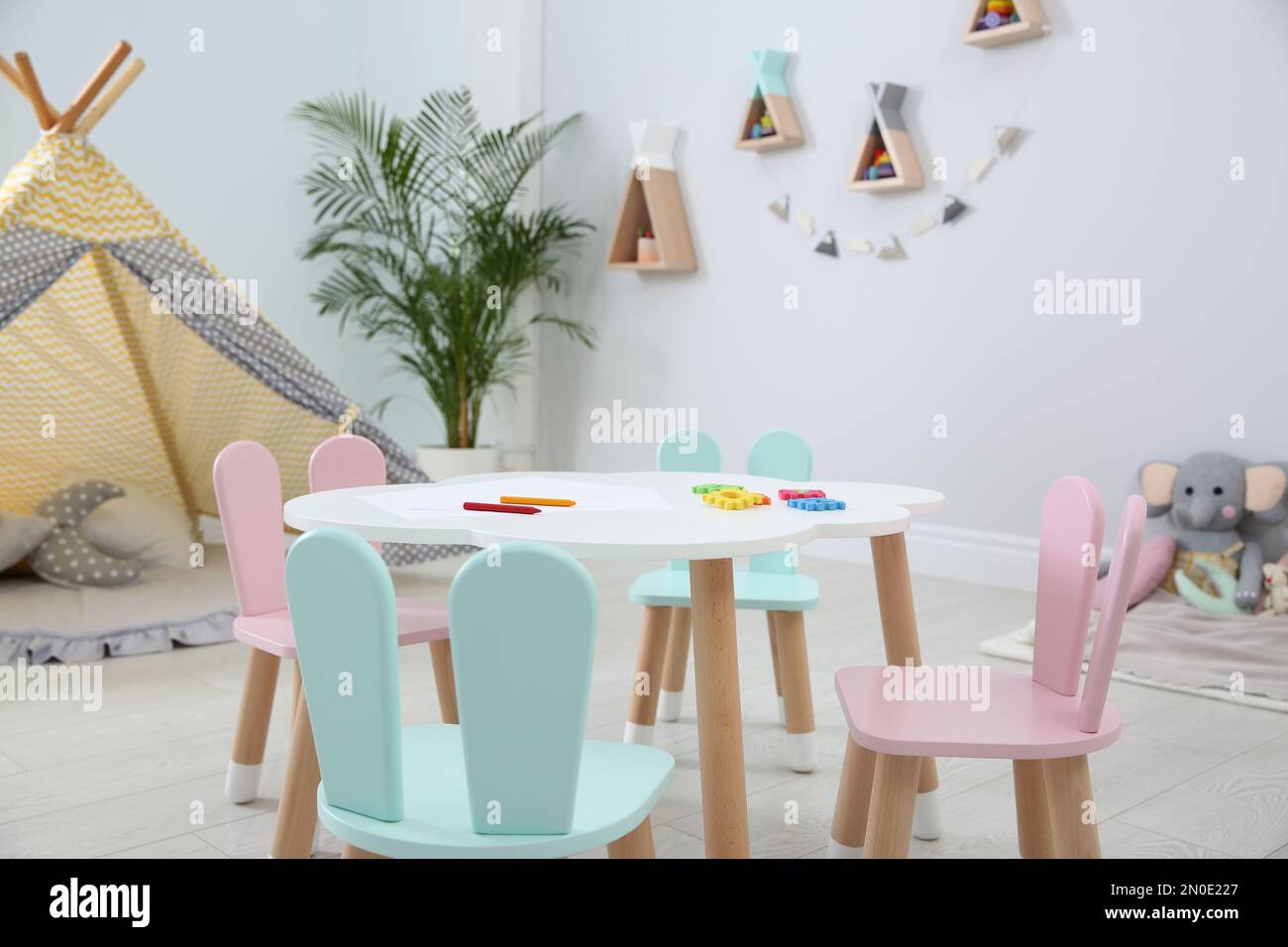 Little table and chairs with bunny ears in children's room. Interior