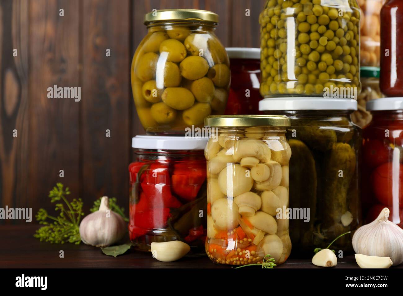 Jars of pickled vegetables on wooden table Stock Photo