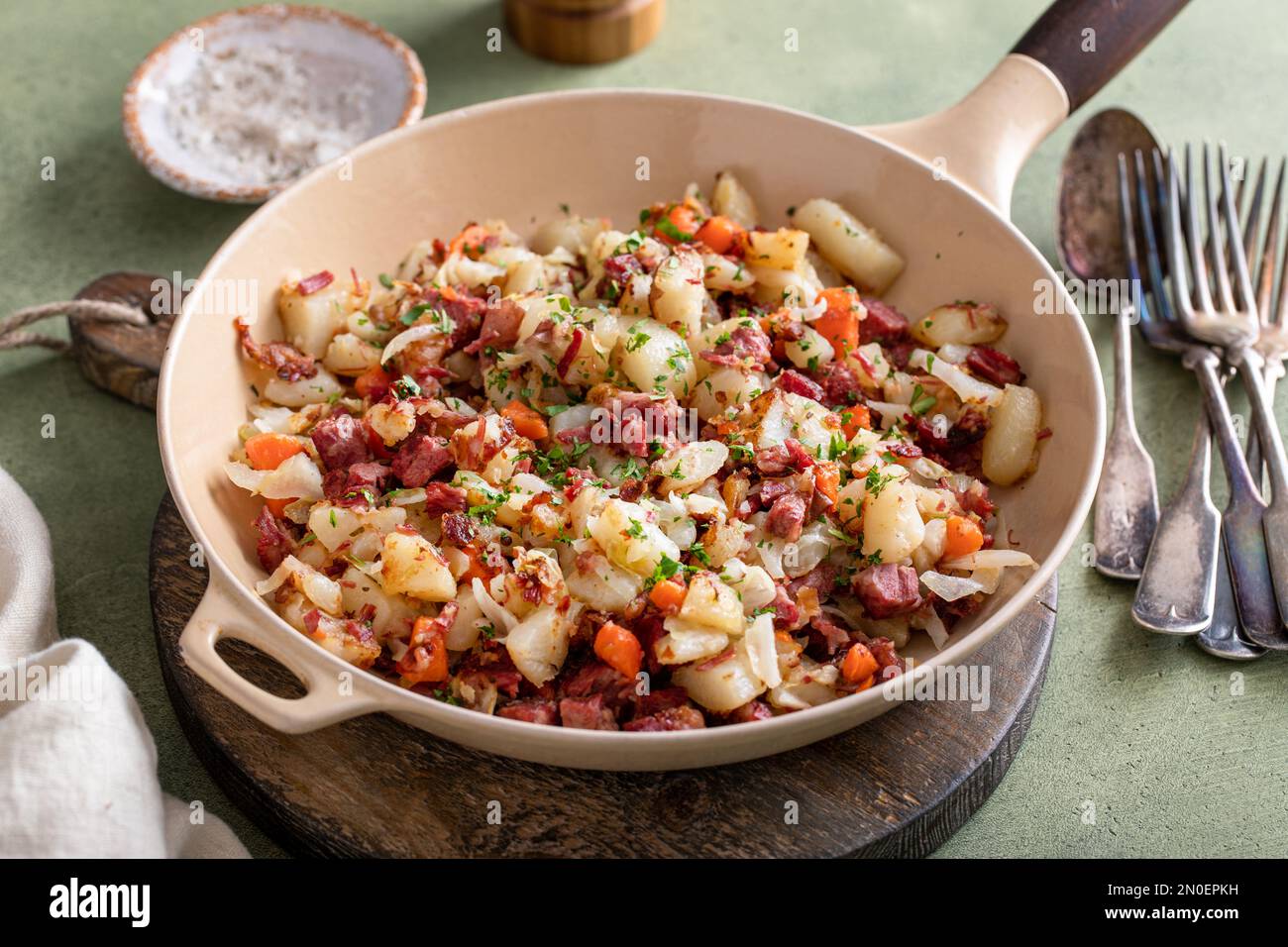 Corned beef hash with potatoes, cabbage and carrot in a cast iron pan