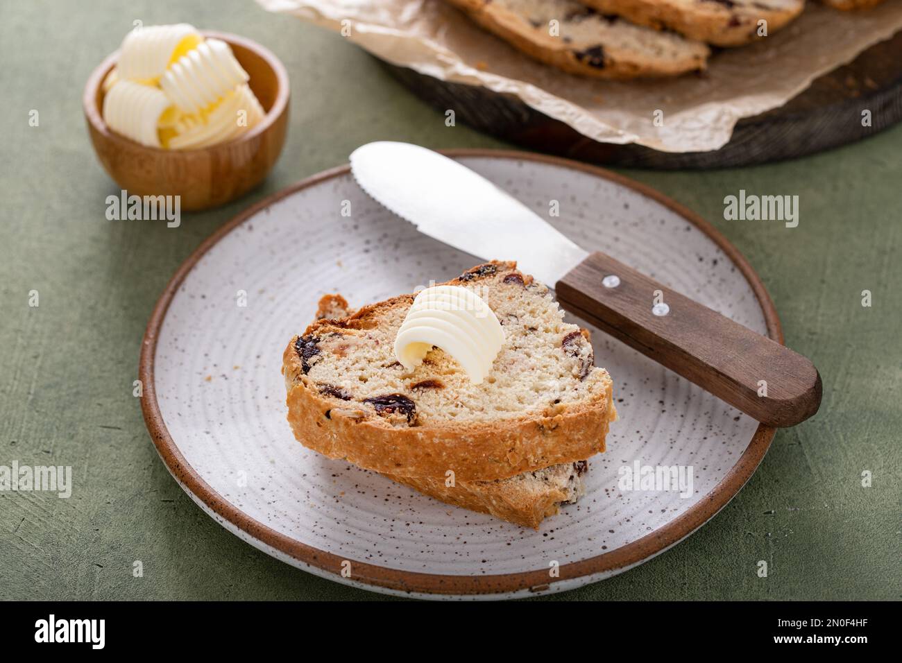 https://c8.alamy.com/comp/2N0F4HF/soda-bread-in-a-cast-iron-pan-with-cranberries-and-pecans-sliced-and-served-with-irish-butter-irish-recipe-idea-with-st-patricks-day-2N0F4HF.jpg