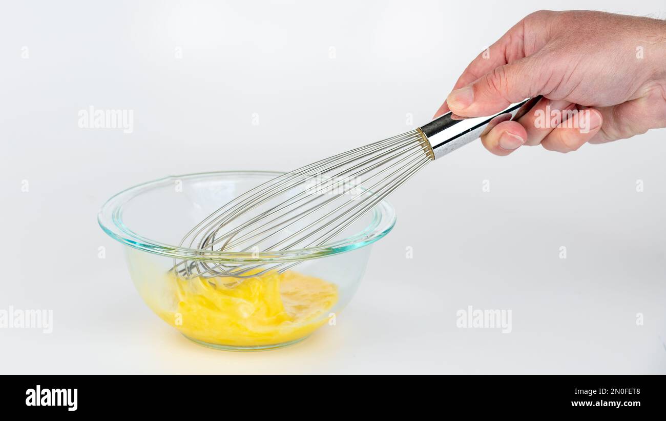 Preparing scrambled eggs with a whisk and bowl Stock Photo Alamy