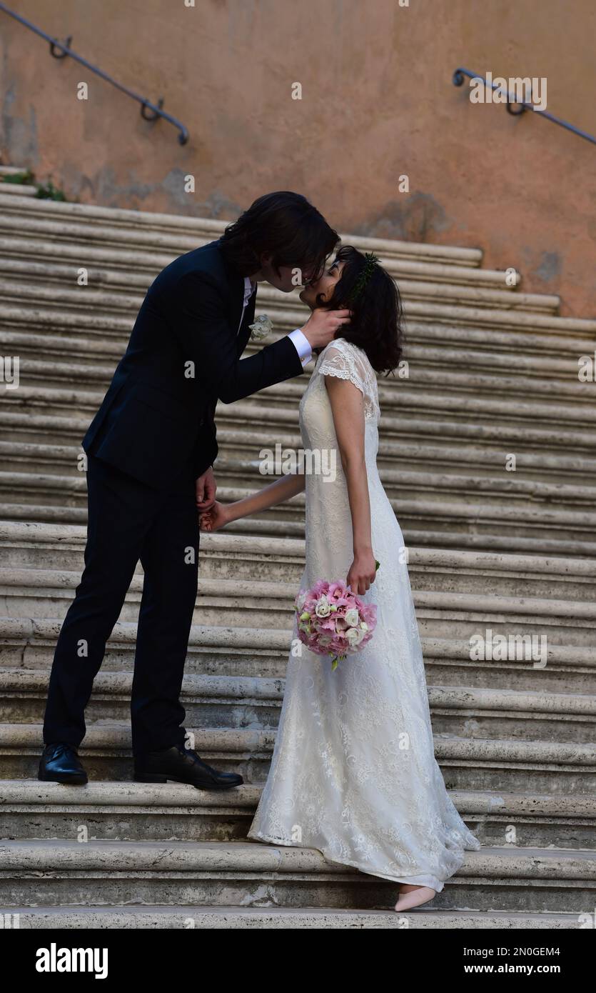 A happy married couple kiss on a flight of steps beside the Palazzo dei Conservatori, Capitol Hill, Rome, Italy, Europe. Stock Photo