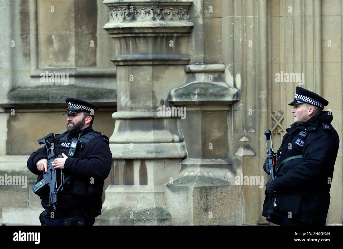 Armed police officers stand guard at the parliament in London, Thursday ...