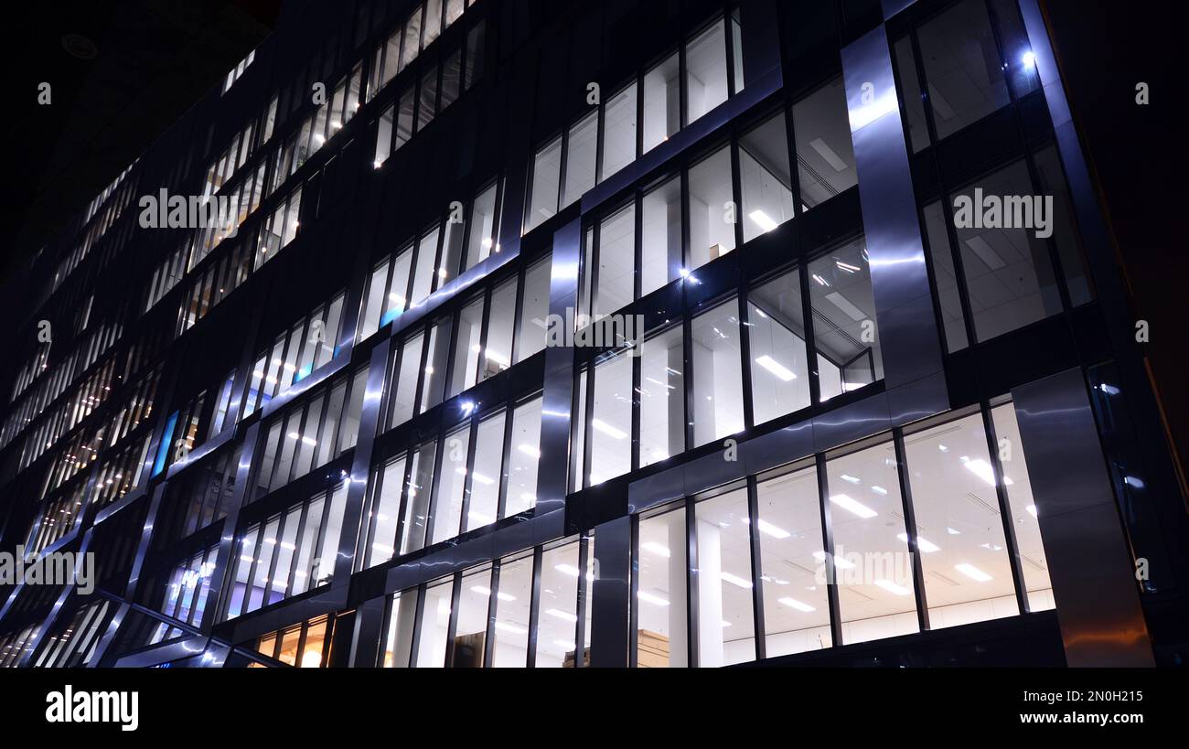 Pattern of office buildings windows illuminated at night. Lighting with  Glass architecture facade design with reflection in urban city Stock Photo  - Alamy