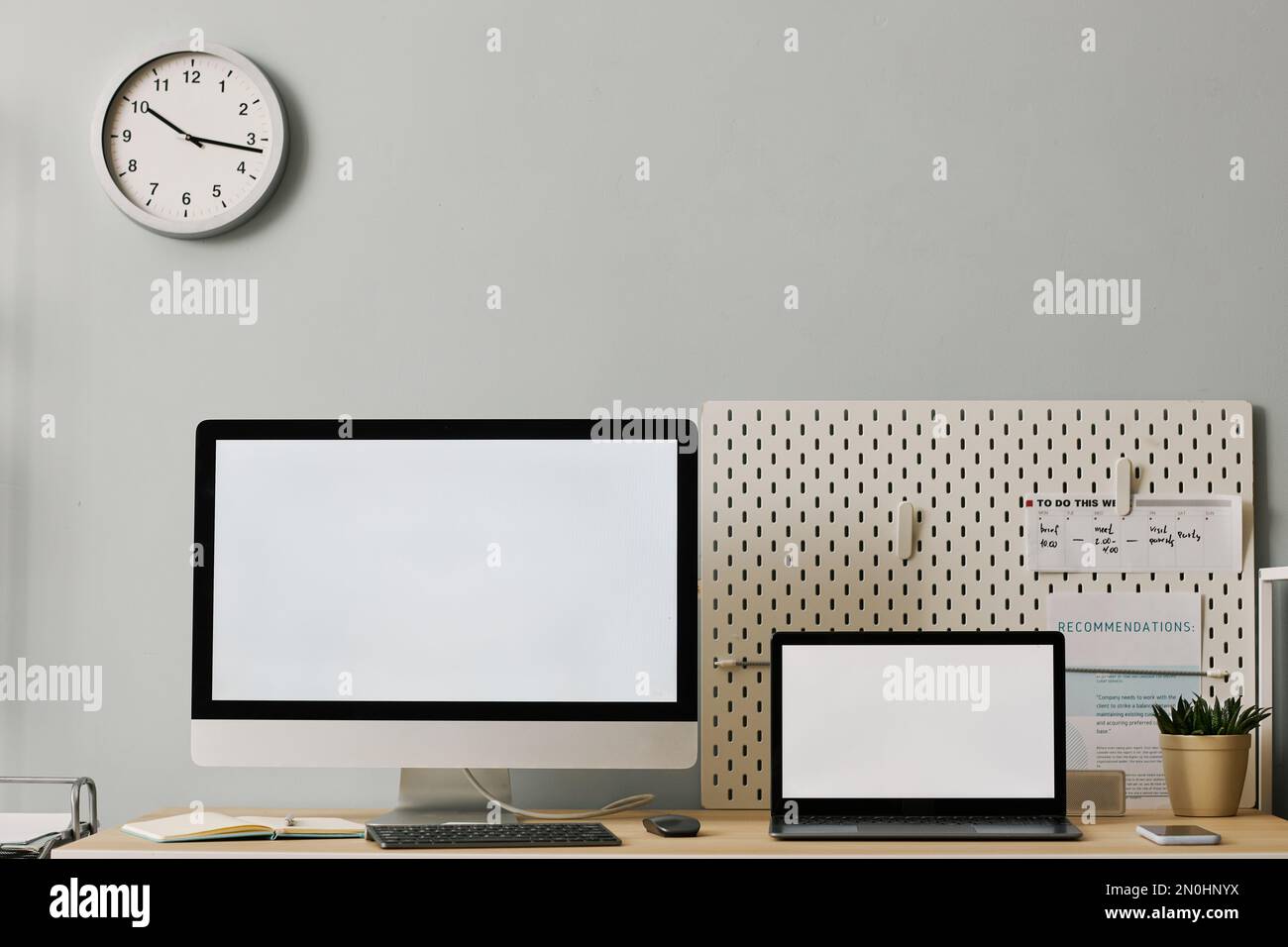 Minimal front view office workplace setup with two screen mockups on desk, copy space Stock Photo
