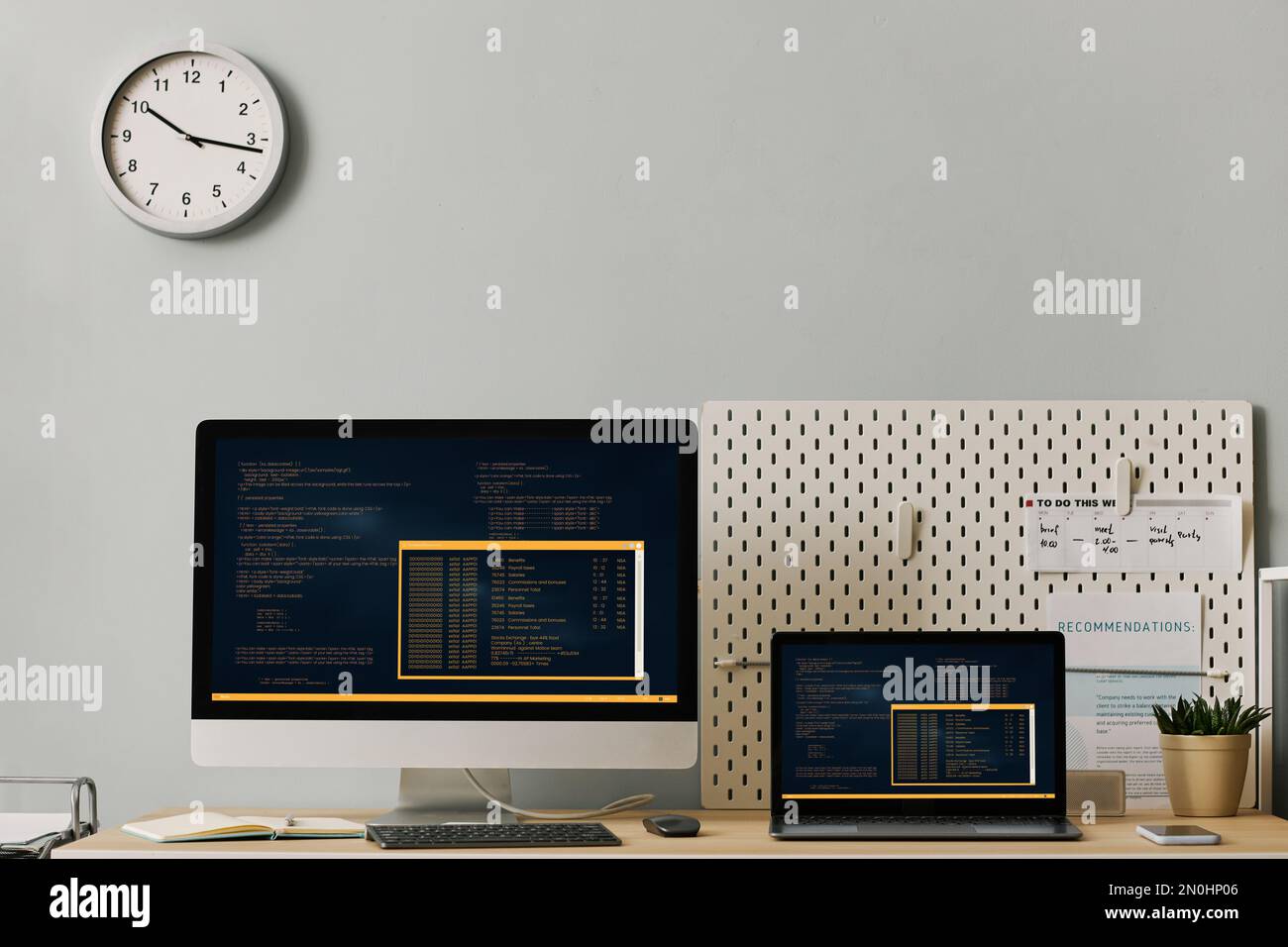 Front view office workplace setup with computer code on two screens ...