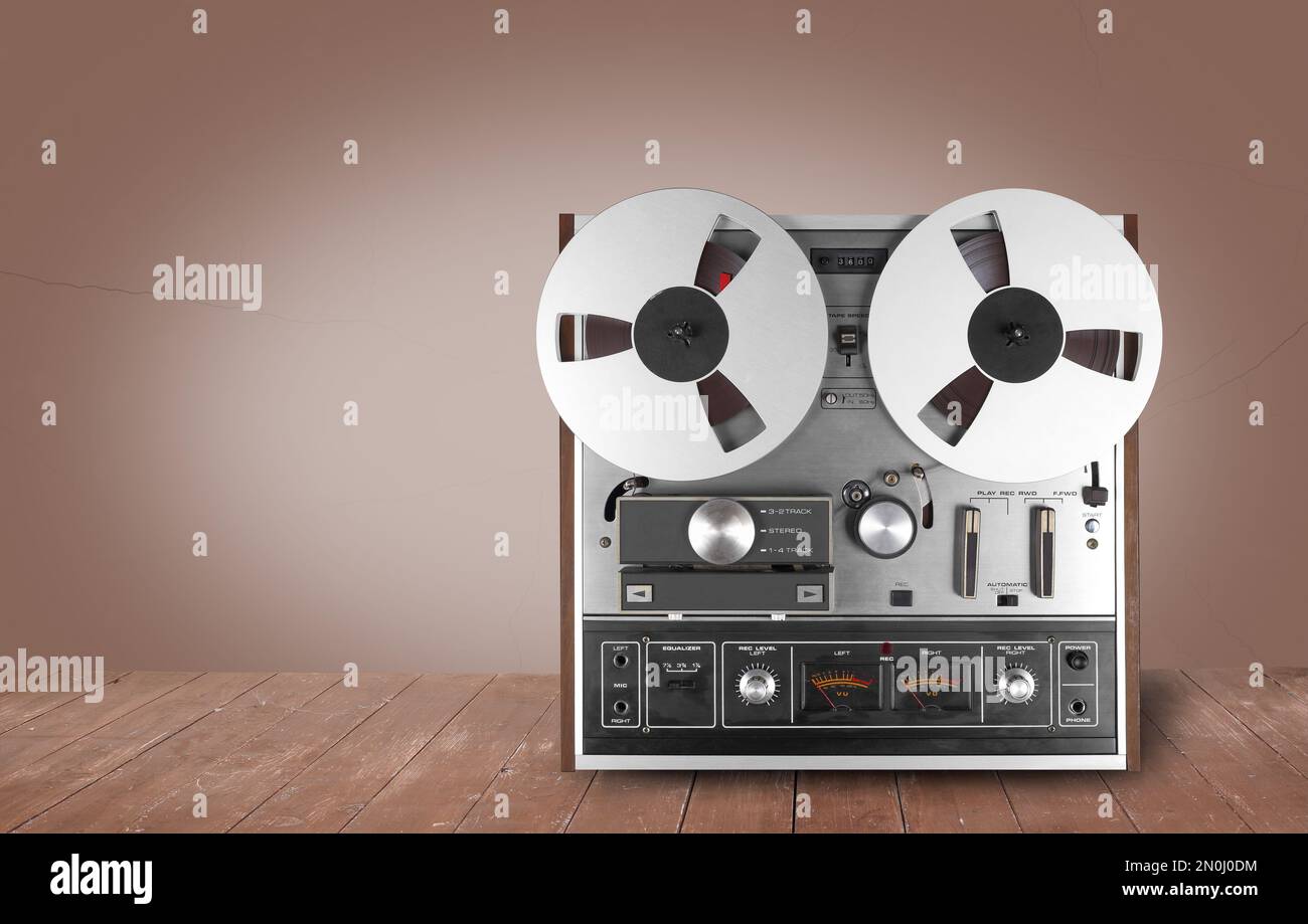 Vintage Music and sound - Retro reel to reel tapes recorder on a wooden  table and a brown background Stock Photo - Alamy