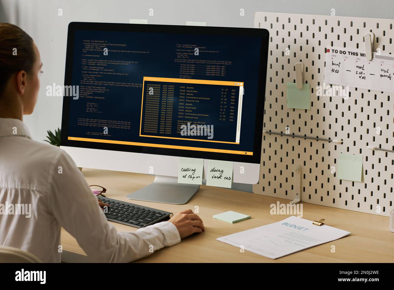 Close up of young woman using computer and writing code while working at desk, copy space Stock Photo