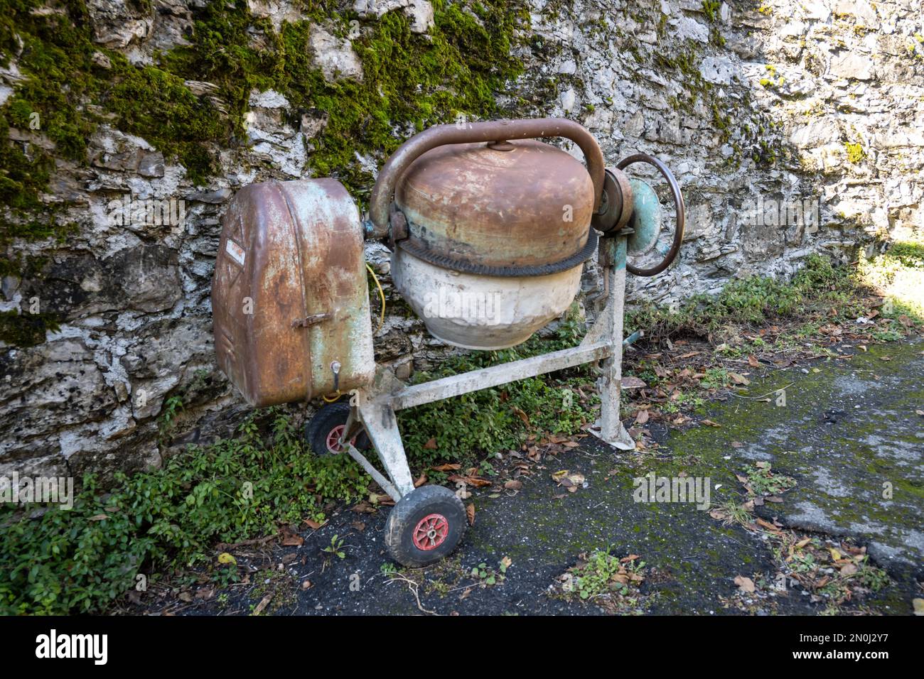 Old concrete mixer used for masonry work now rusted by time Stock Photo