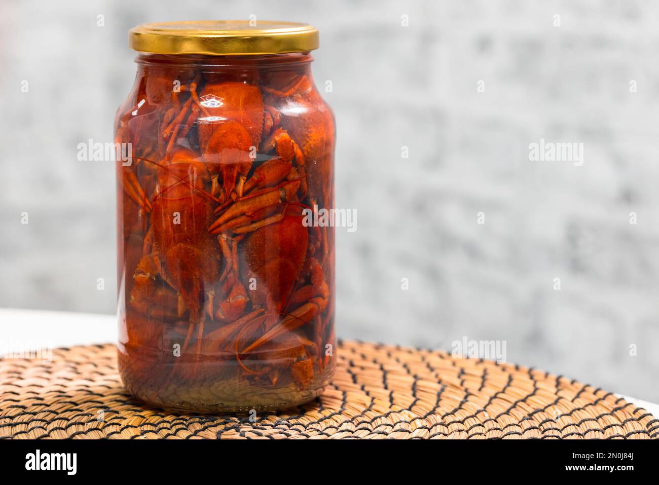 Red pickled crayfish in a glass jar, close up photo with selective soft focus Stock Photo