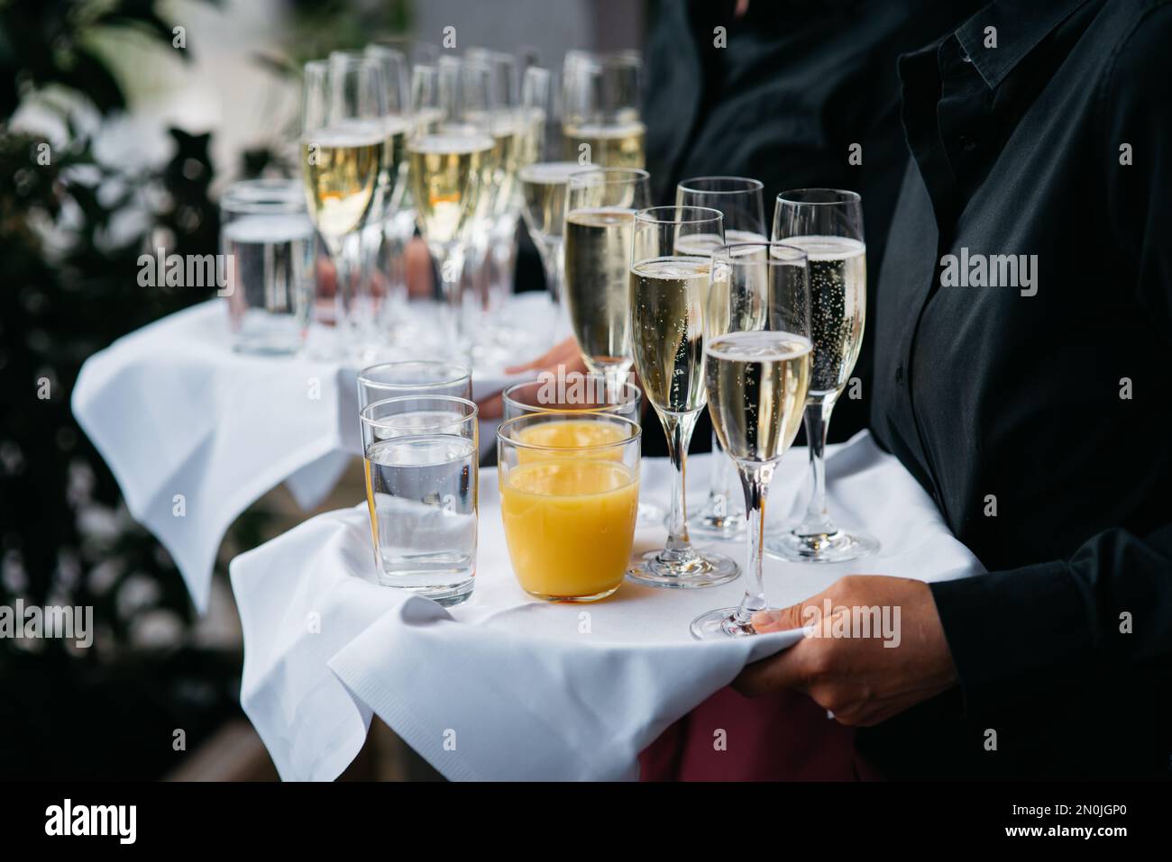The Waiter with sparkling wine, water and orange juice Stock Photo Alamy