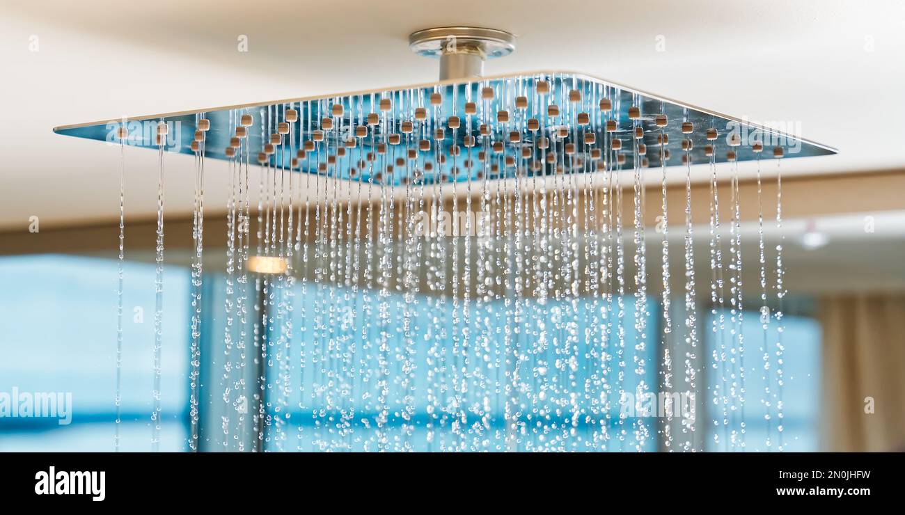 Water flows from the tropical shower. Large water consumption. Chrome