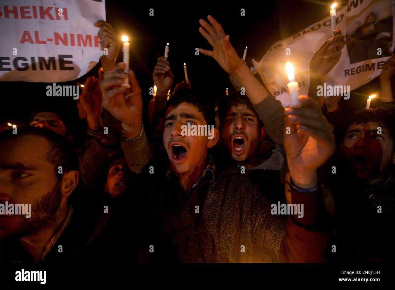 Kashmiri Shiite Muslims shout slogans as they hold candles during a ...