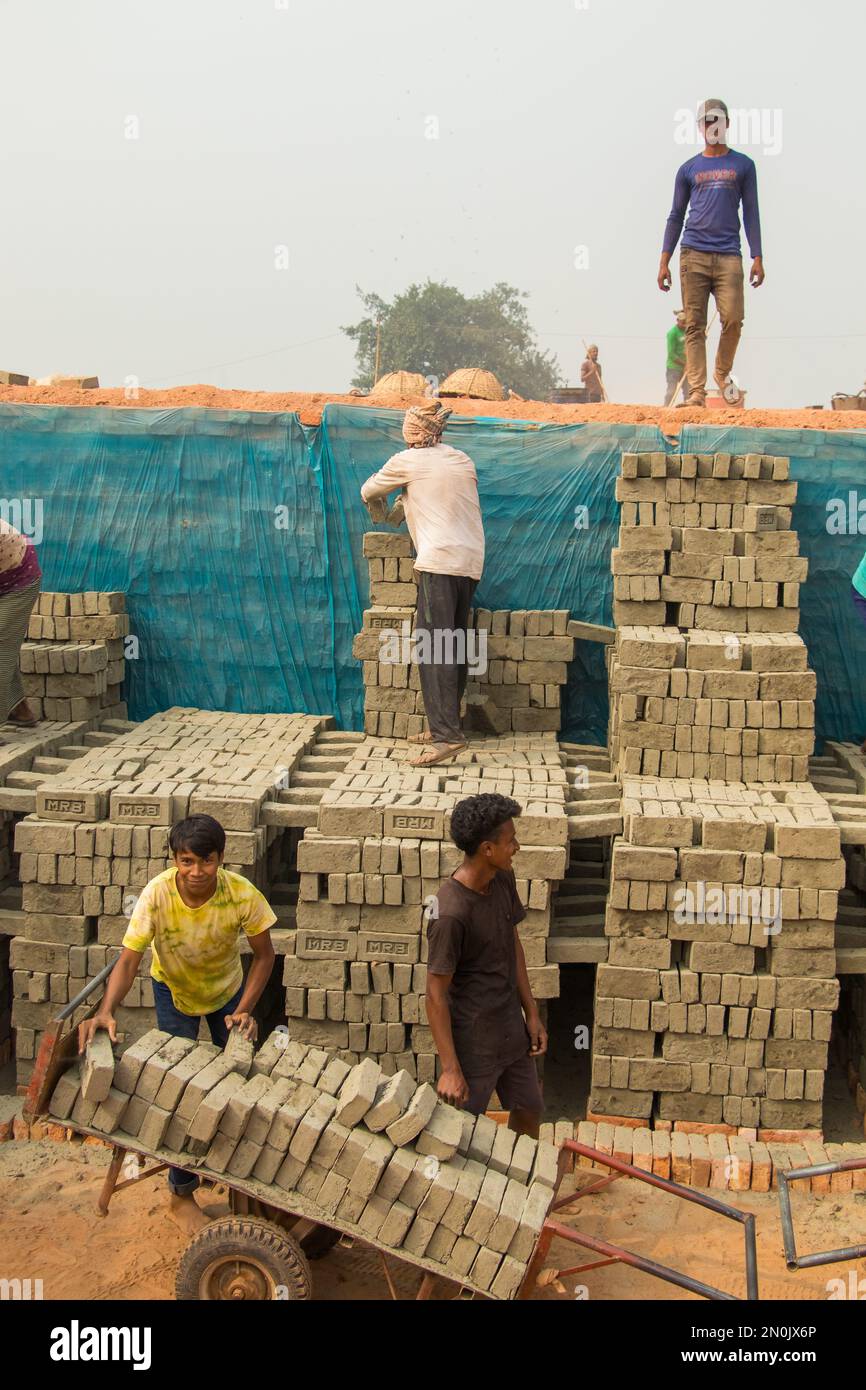 People are working hard in the brick field. This image was taken from Bosela, Bangladesh on December 30, 2022 Stock Photo