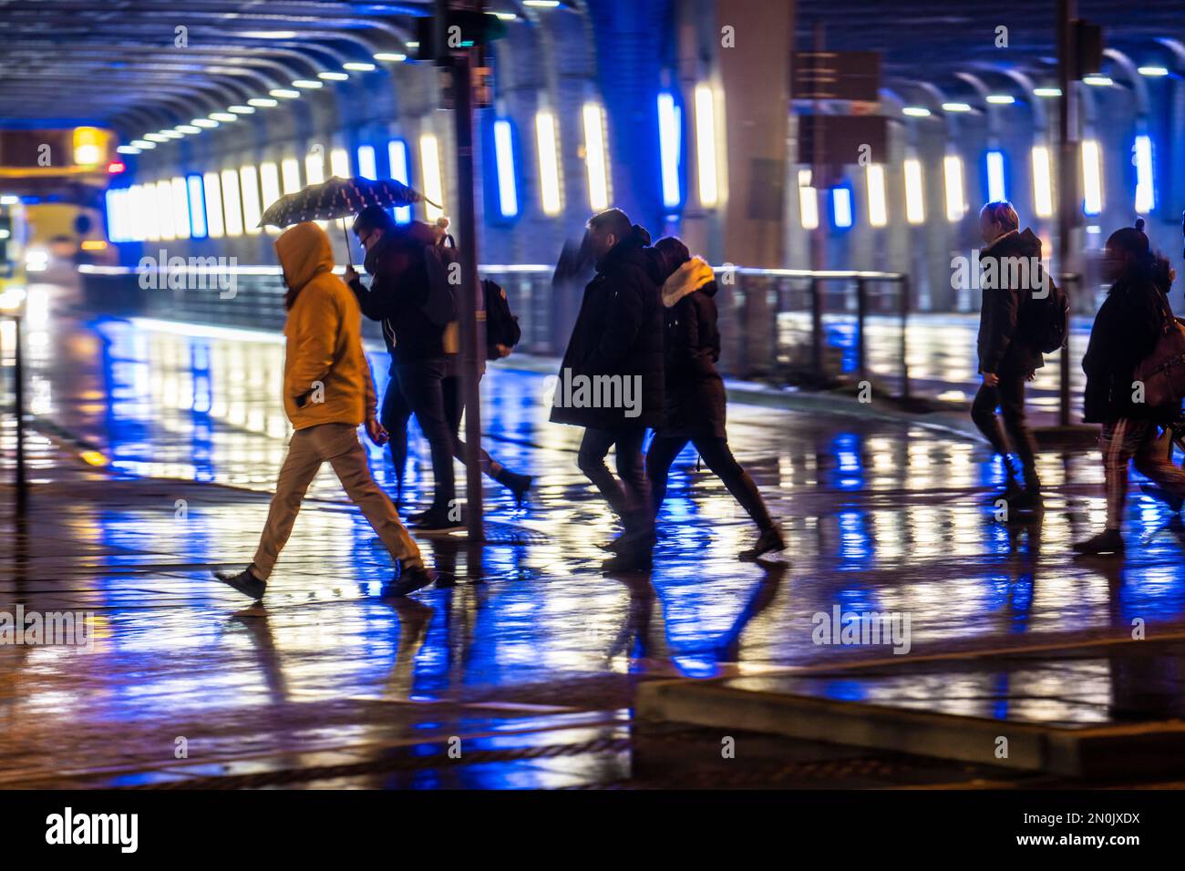 Illuminated subway at the main station, passers-by at a pedestrian crossing, rainy weather, city centre, in the evening, Essen, NRW, Germany, Stock Photo