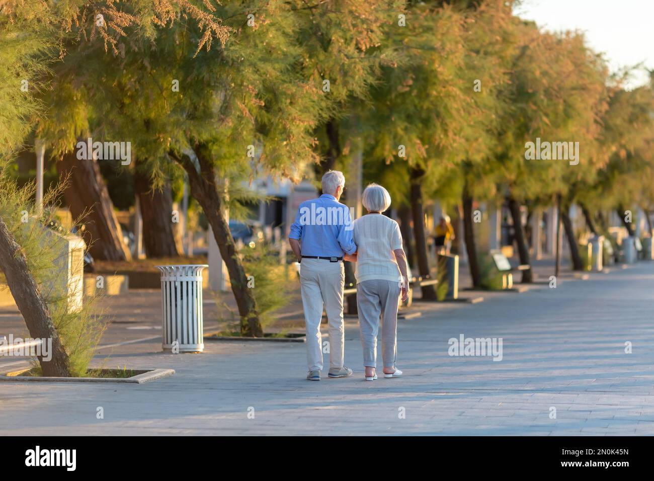 Elderly couple walking hand in hand on the promenade Stock Photo - Alamy