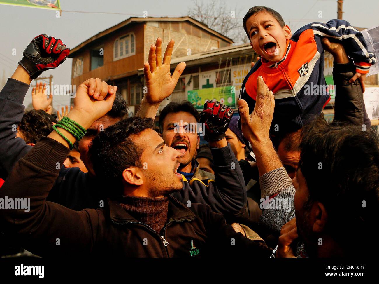 A young Kashmiri Shiite Muslim boy is lifted by others as they shout ...
