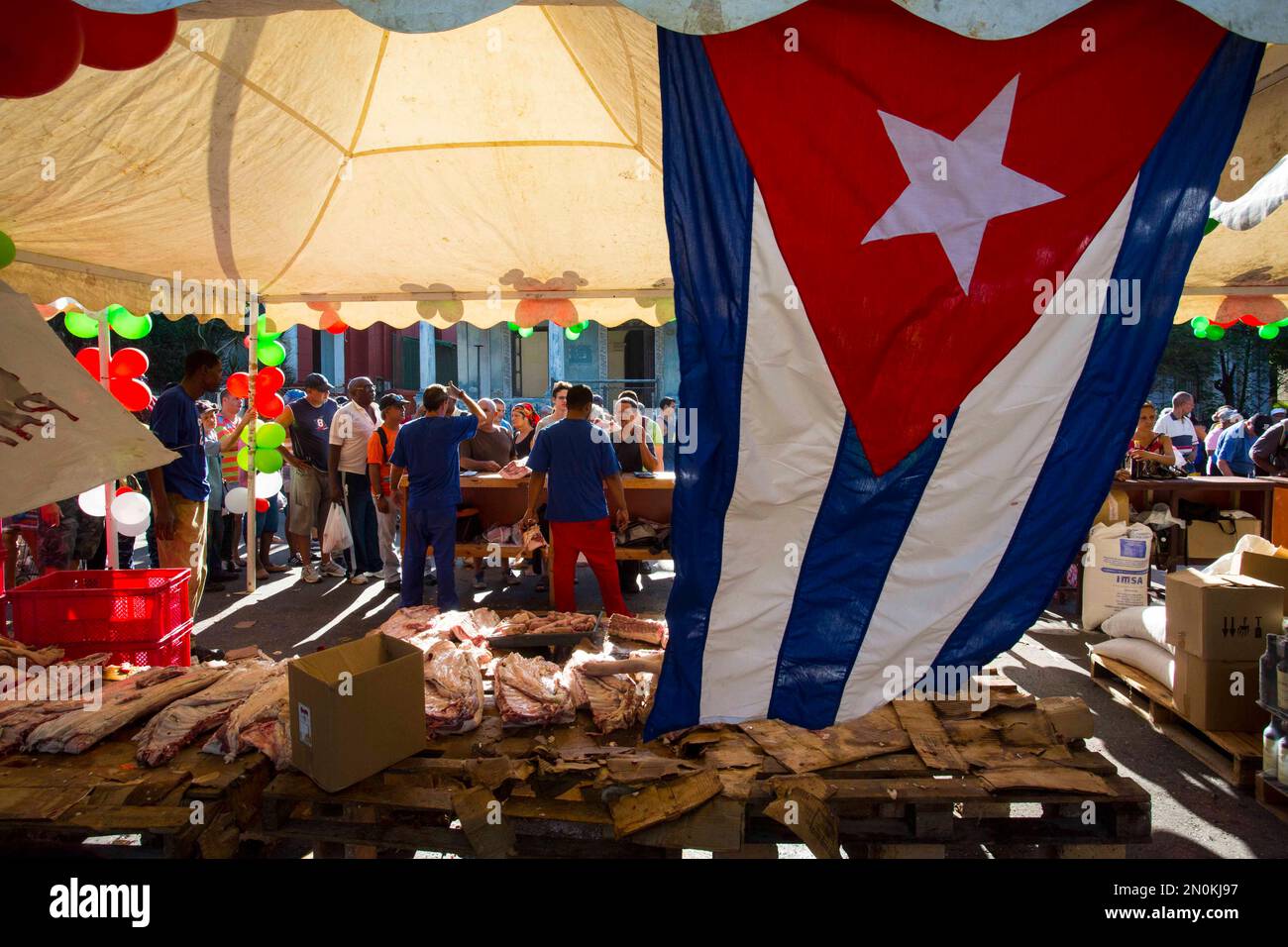 Shoppers buy pork meat at an outdoor staterun food market where a