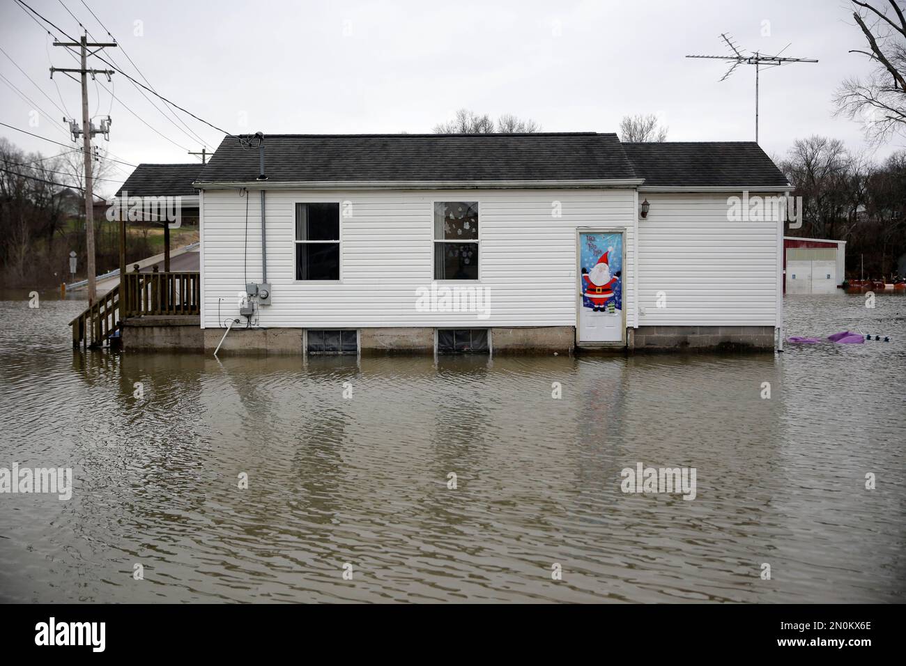 A Christmas decoration hangs on the door of a home surrounded by