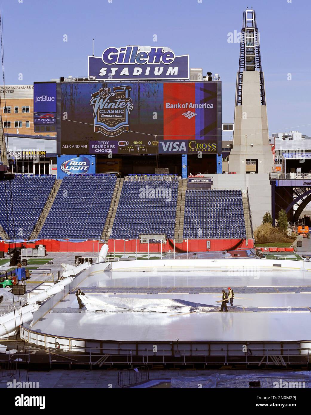 Workers prepare the Winter Classic hockey rink on the football field of