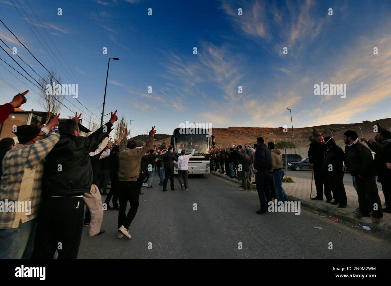Syrian and Lebanese wave and flash victory signs as convoys carrying