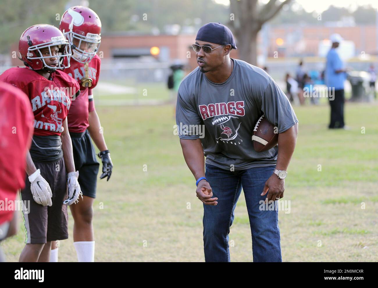 IMAGE DISTRIBUTED FOR NATIONAL FOOTBALL LEAGUE - In this photo released by  the NFL, former NFL player Brian Dawkins coaches Raines football players  during practice after a Super Bowl High School Honor