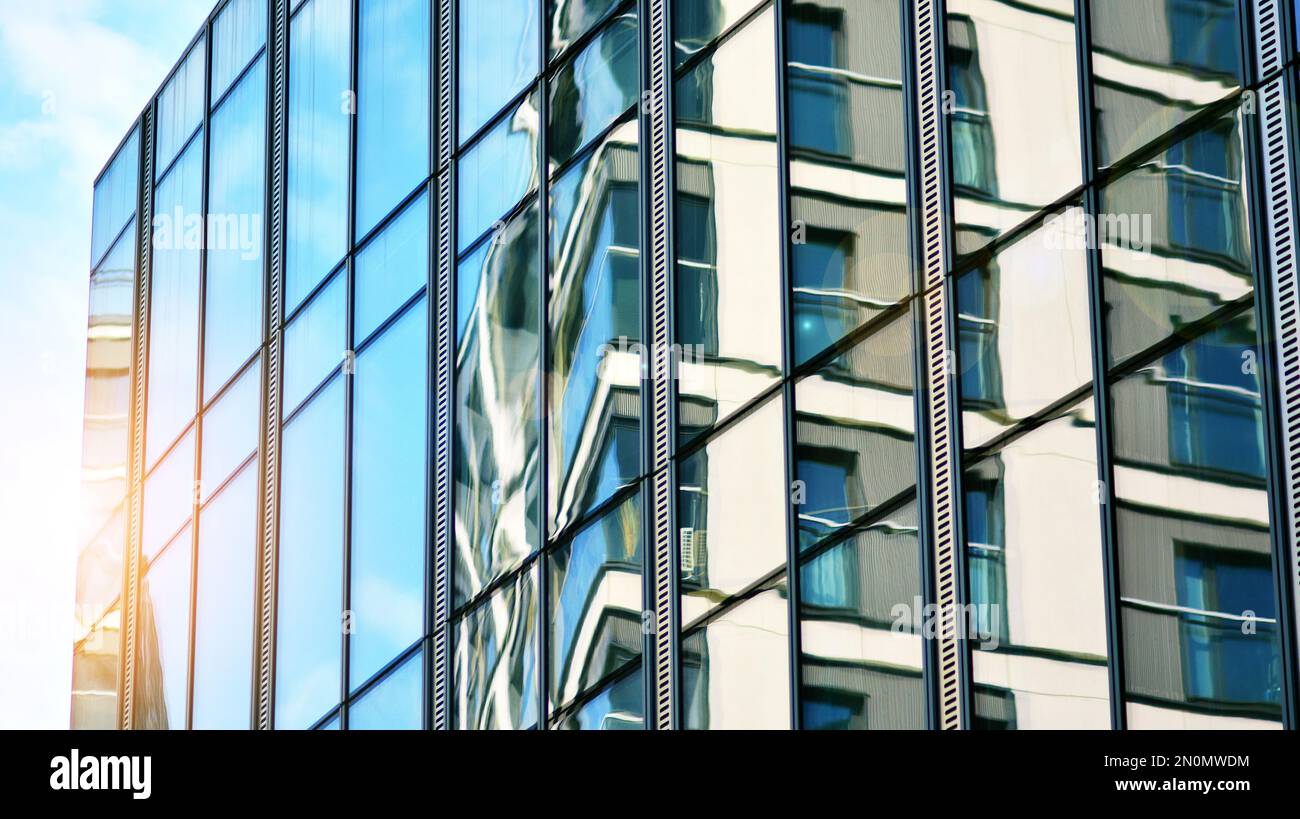 Blue sky and clouds reflected in windows of modern office building ...