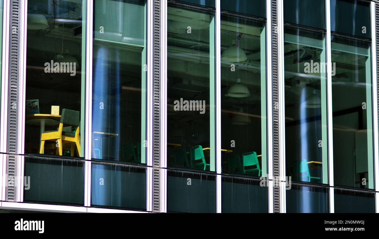Blue sky and clouds reflected in windows of modern office building ...