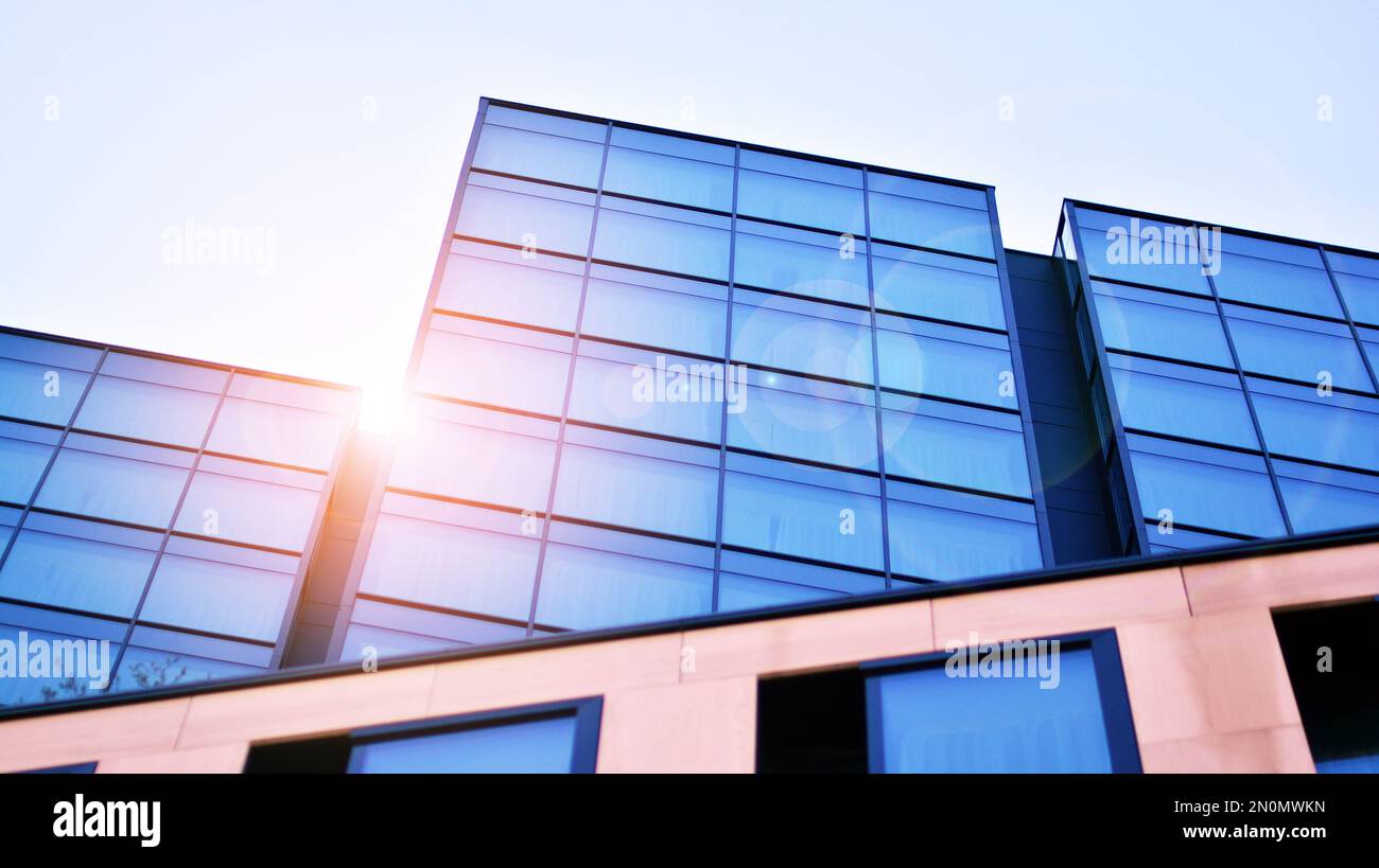 Blue sky and clouds reflected in windows of modern office building ...