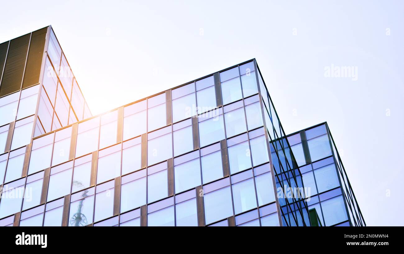 Blue sky and clouds reflected in windows of modern office building ...