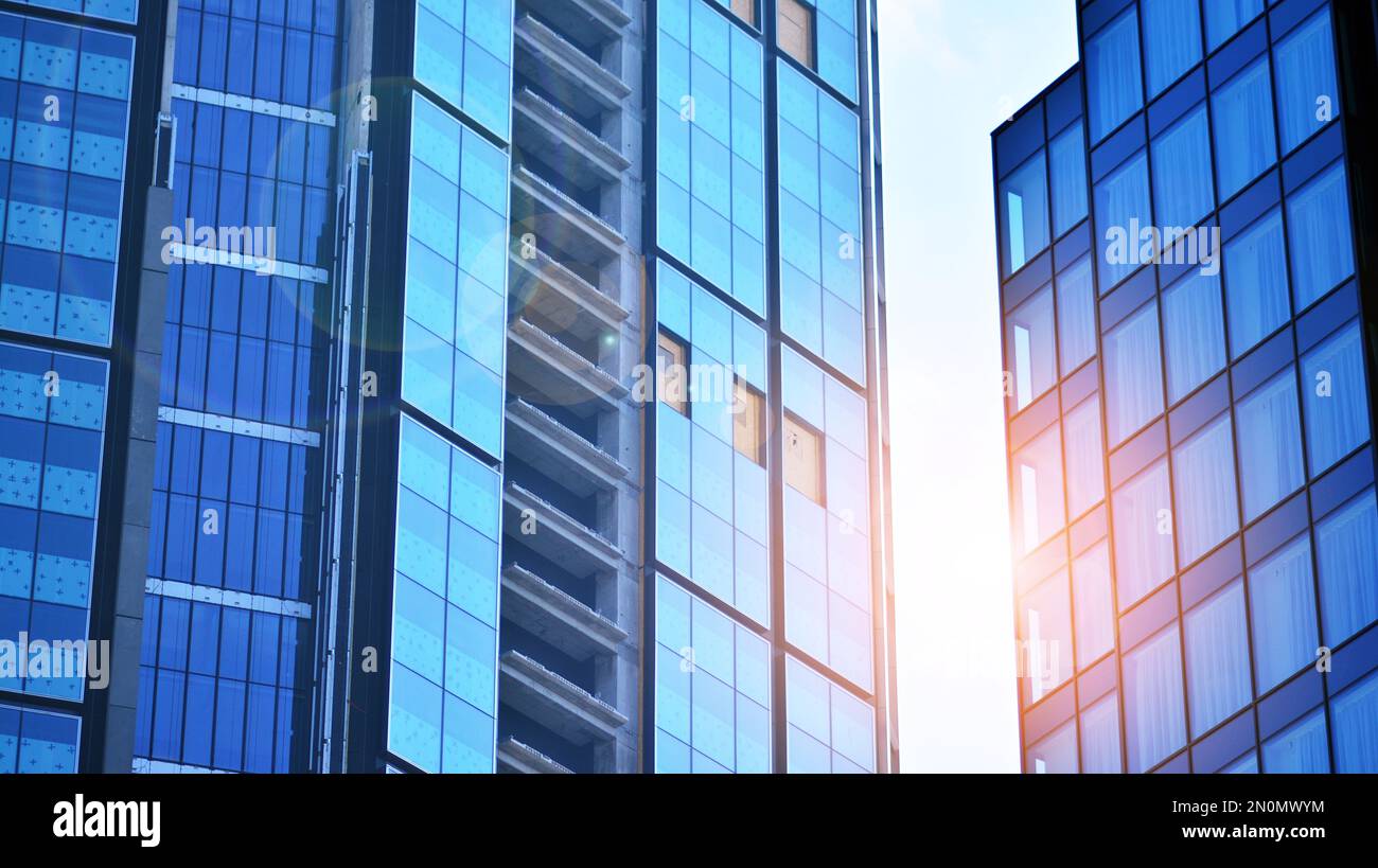 Blue sky and clouds reflected in windows of modern office building ...