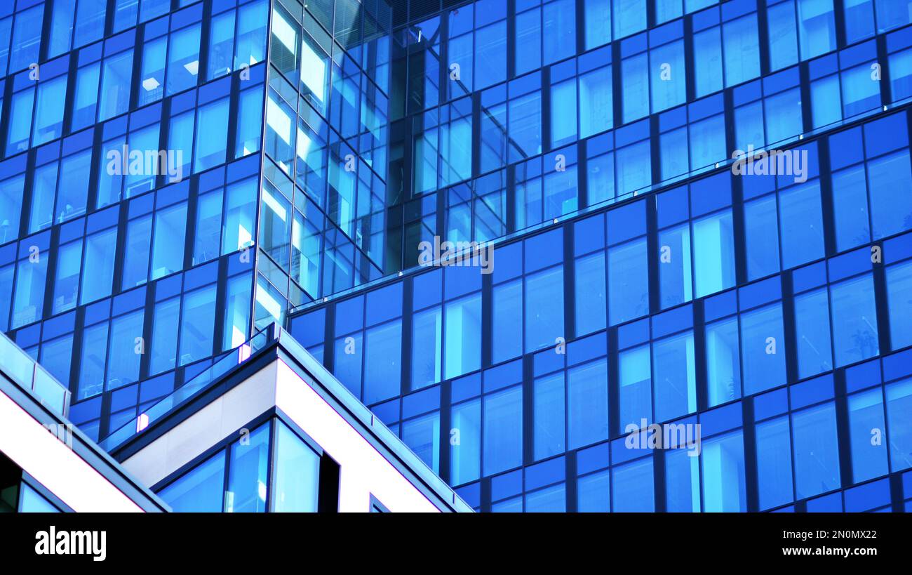 Blue sky and clouds reflected in windows of modern office building ...