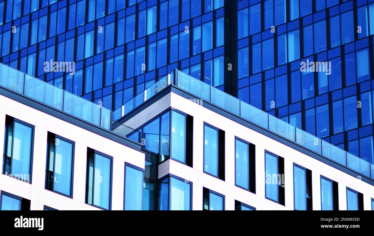 Blue sky and clouds reflected in windows of modern office building ...