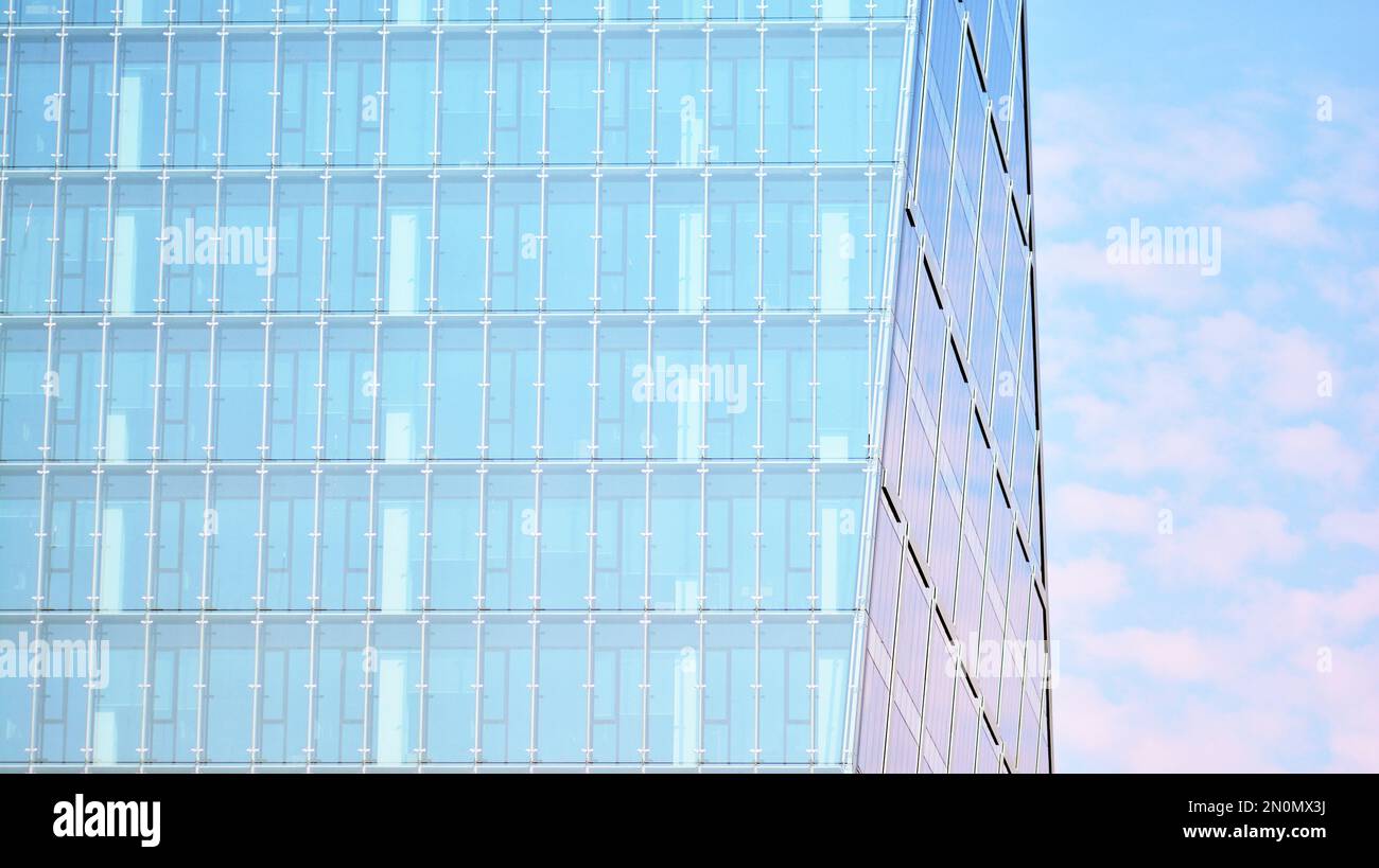 Blue sky and clouds reflected in windows of modern office building ...