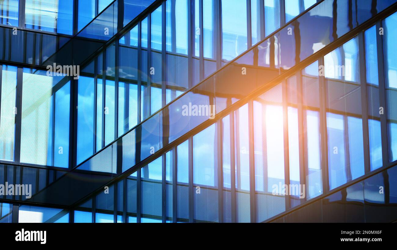 Blue sky and clouds reflected in windows of modern office building ...