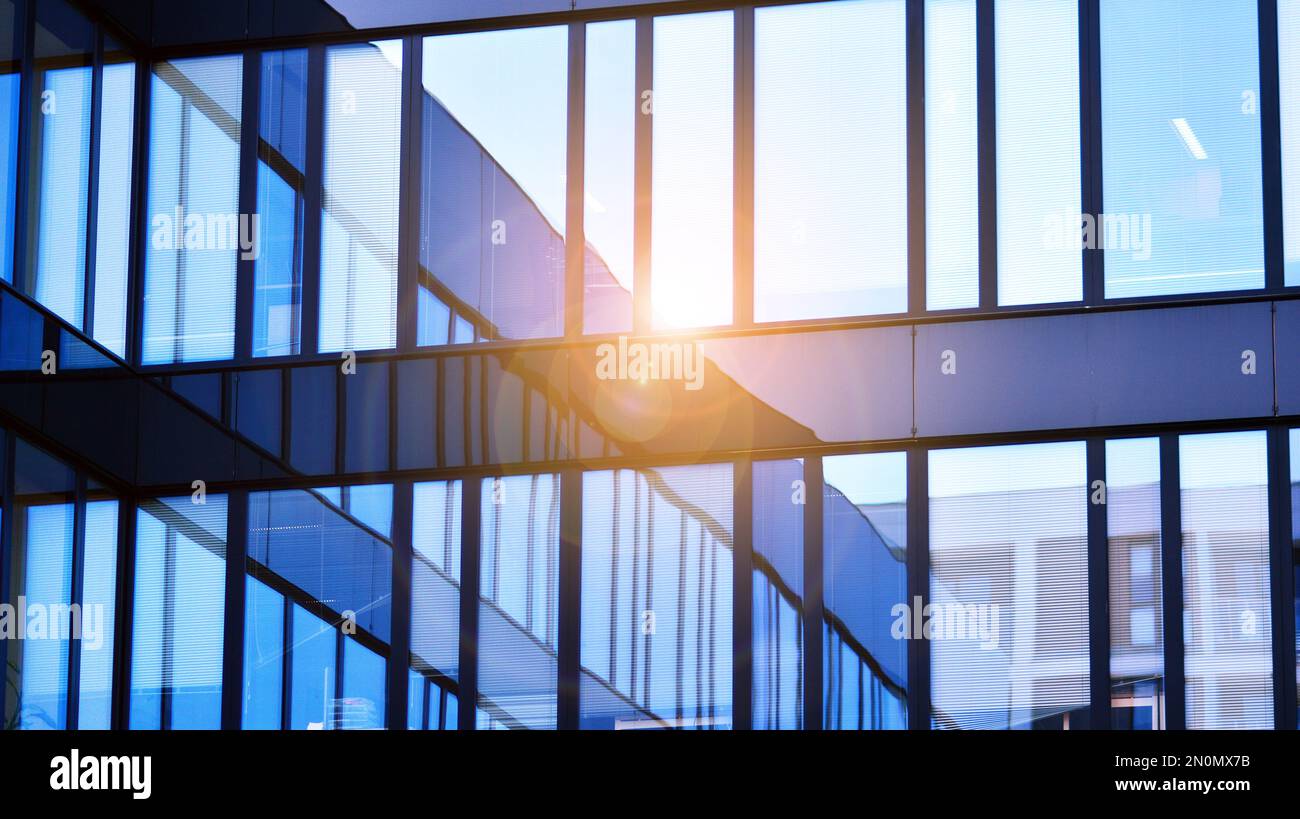 Blue sky and clouds reflected in windows of modern office building ...