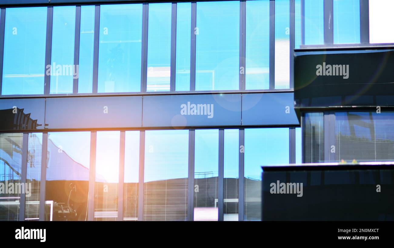 Blue sky and clouds reflected in windows of modern office building ...