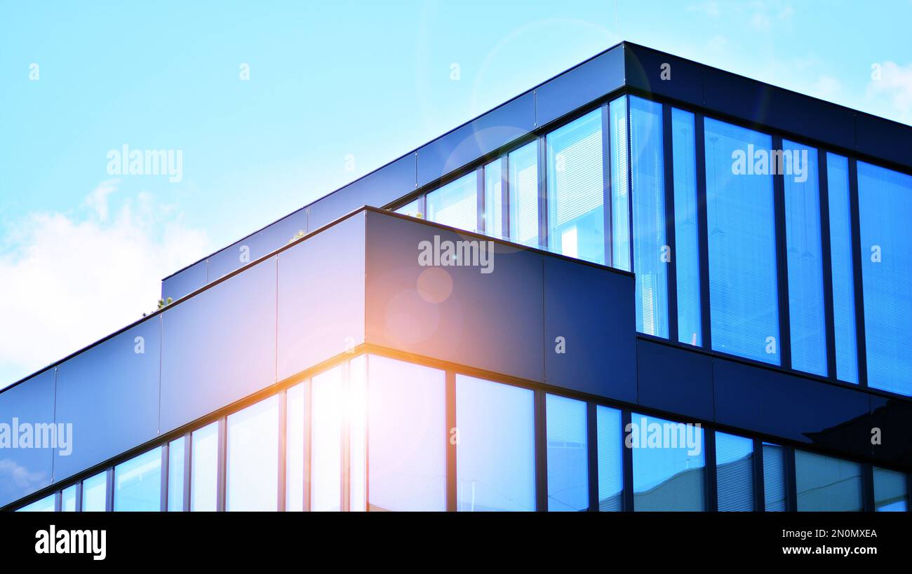 Blue sky and clouds reflected in windows of modern office building ...