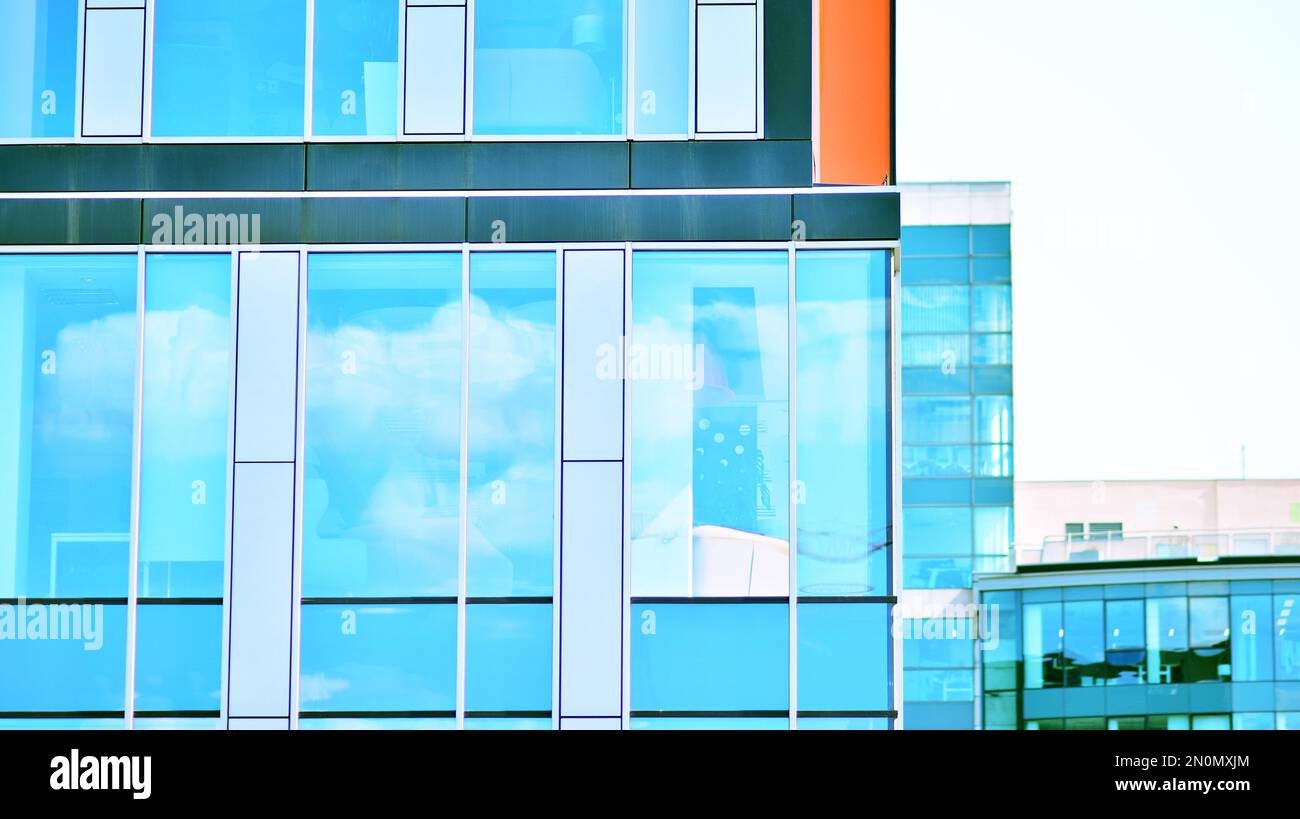 Blue sky and clouds reflected in windows of modern office building ...