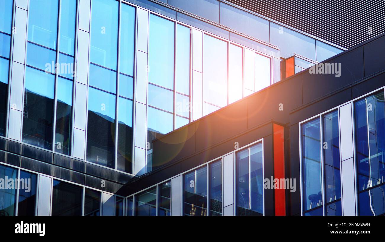 Blue sky and clouds reflected in windows of modern office building ...