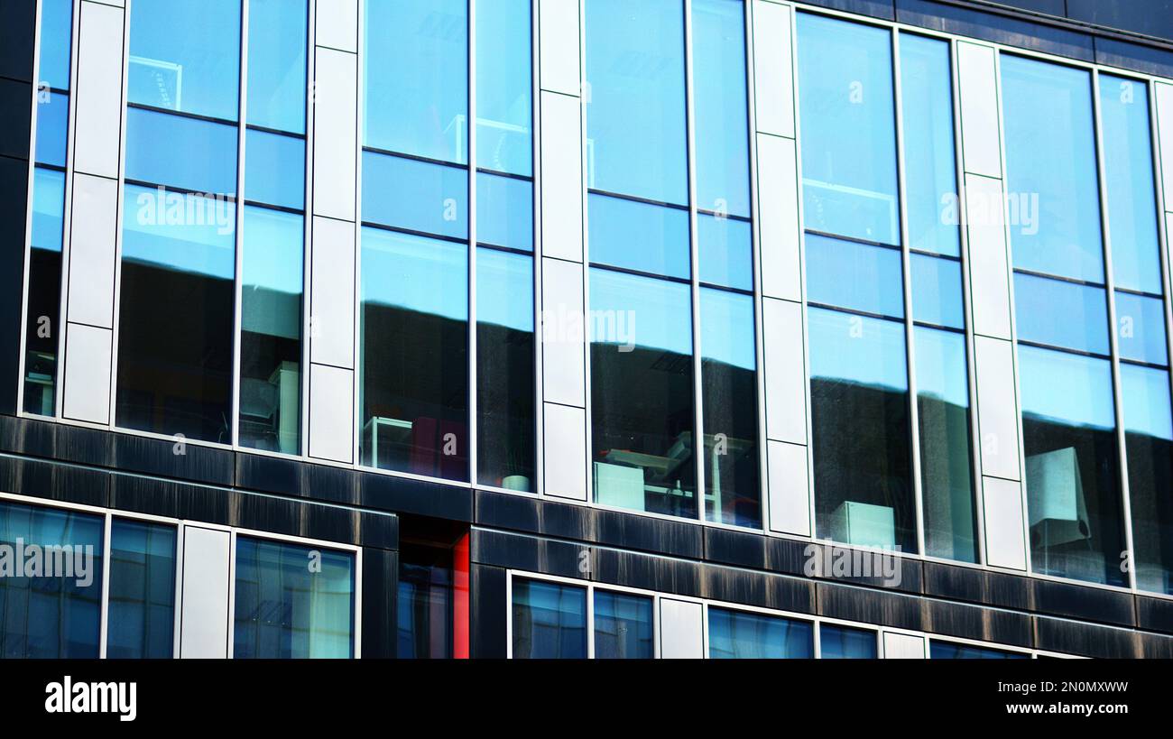 Blue sky and clouds reflected in windows of modern office building ...