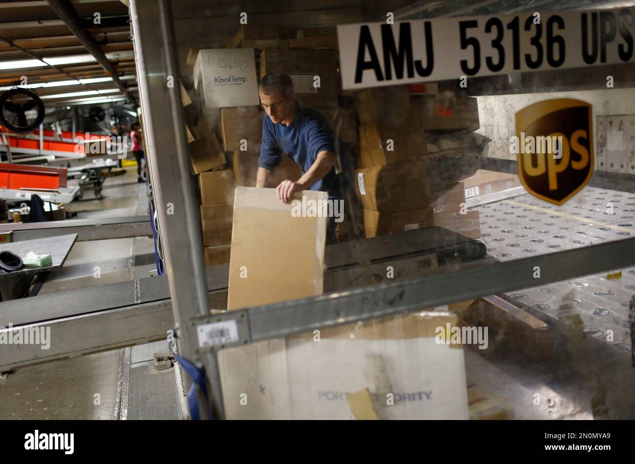 In this Nov. 20, 2015 photo, UPS employee Justin Sims prepares to place