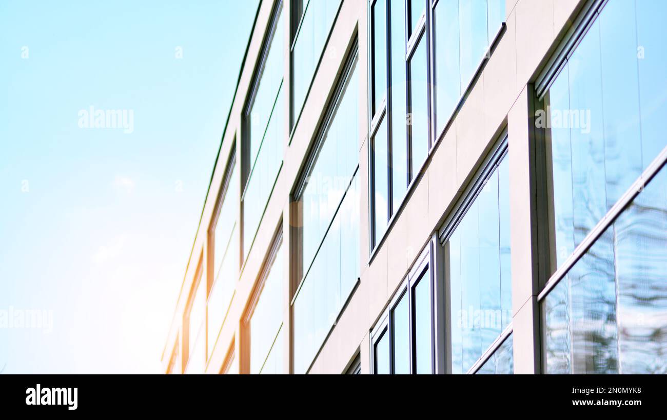 Blue sky and clouds reflected in windows of modern office building ...