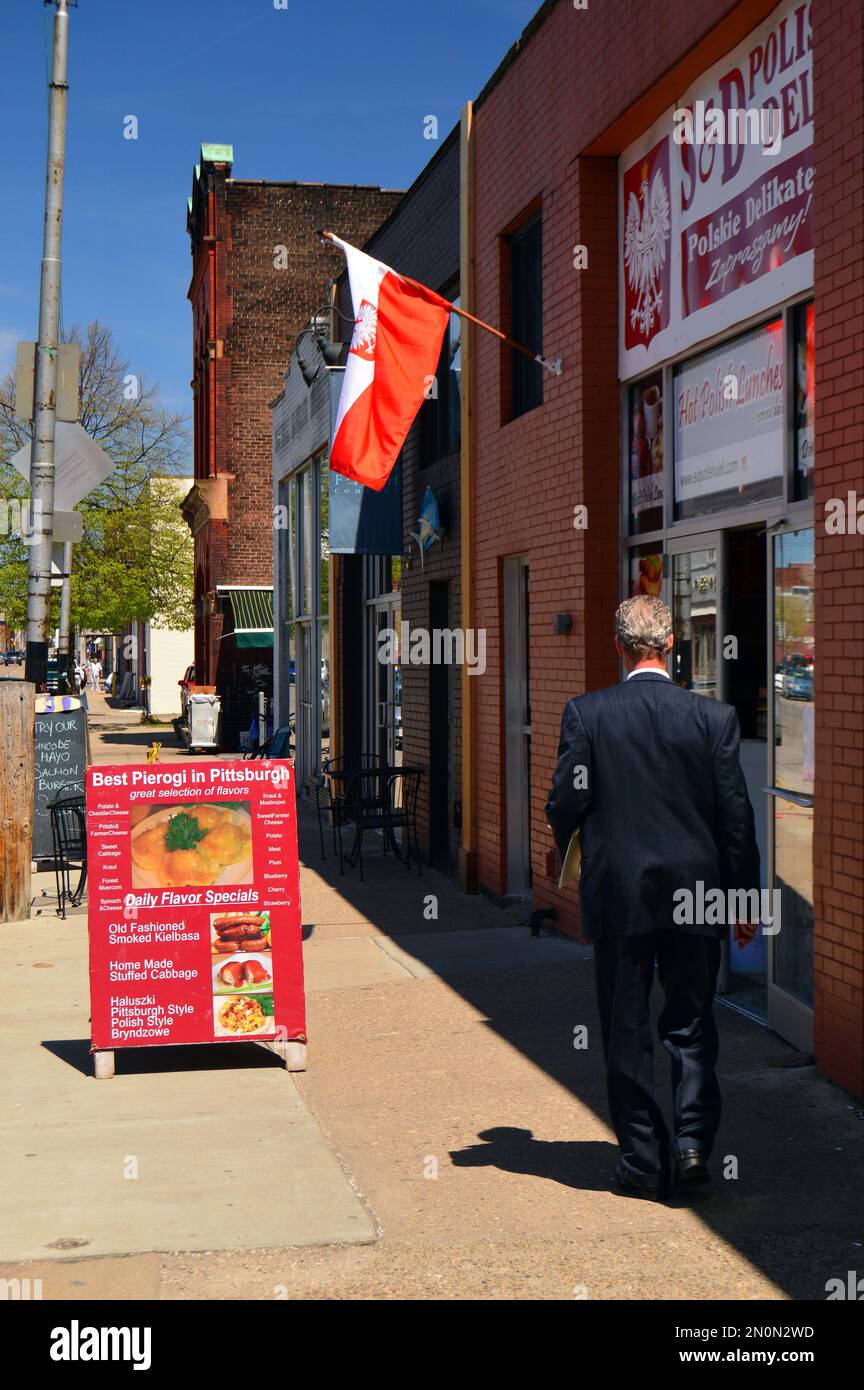 An adult man walks by a Polish deli in the Strip district of Pittsburgh
