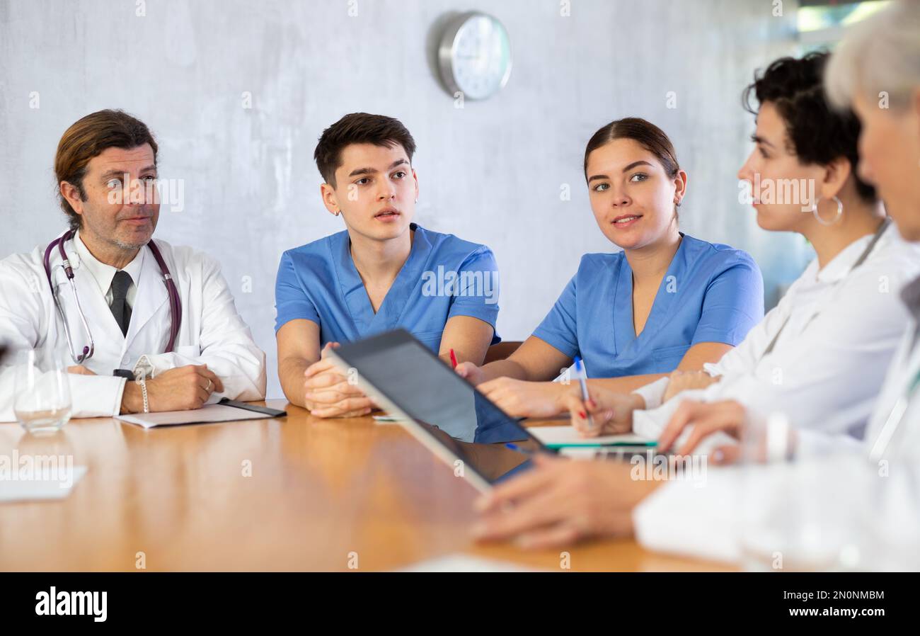 Doctors discussing diagnosis during medical council at table Stock Photo