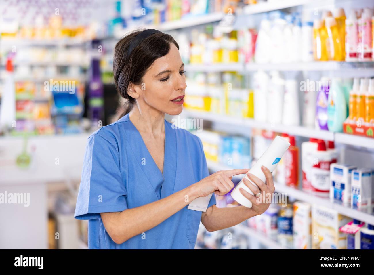 Female pharmacist offering product working in drugstore Stock Photo Female pharmacist offering product working in drugstore Stock Photo