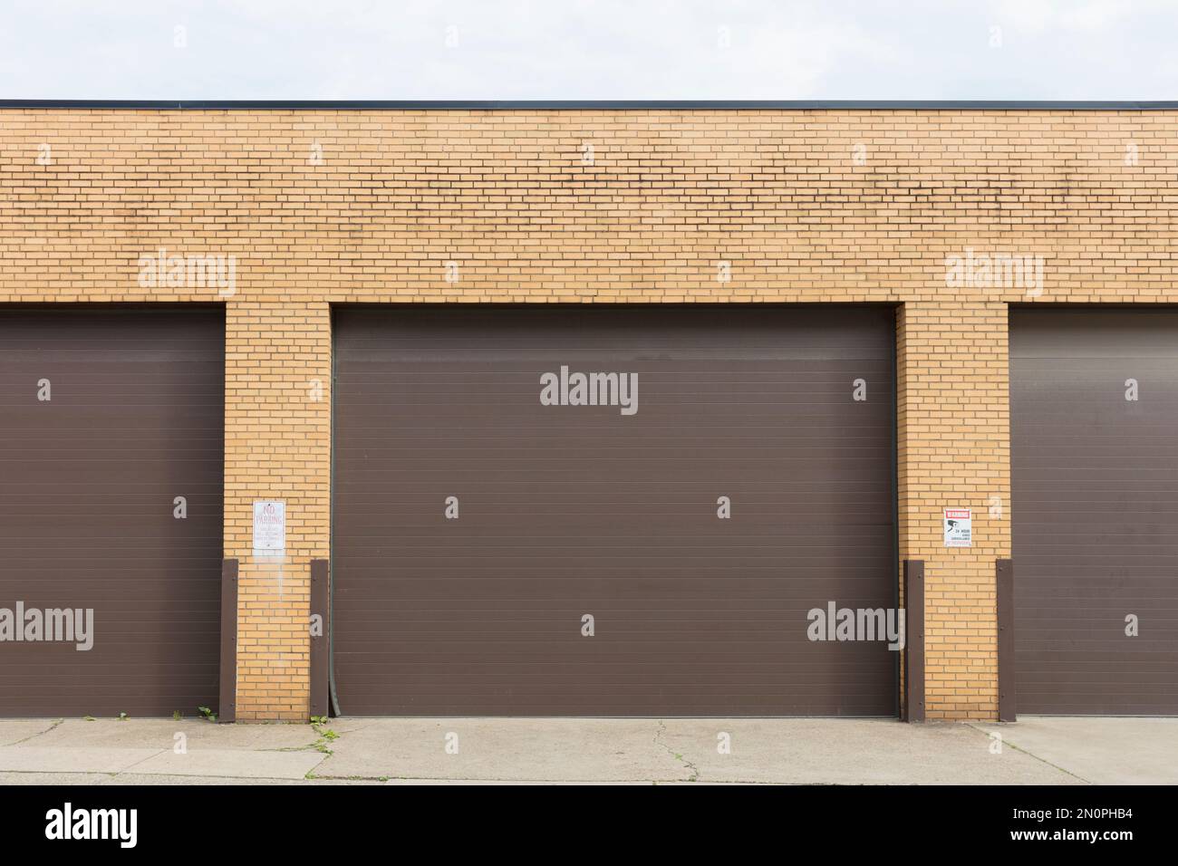 Exterior of industrial warehouse roll down doors and doorway pillars. Stock Photo