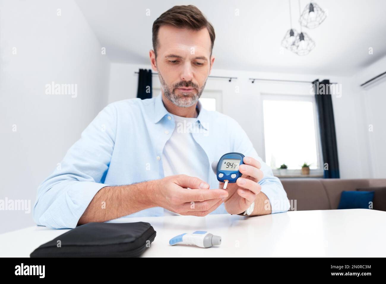Man Using Glucometer Man measures his blood sugar. Glucometer, blood sample test, diabetes ...
