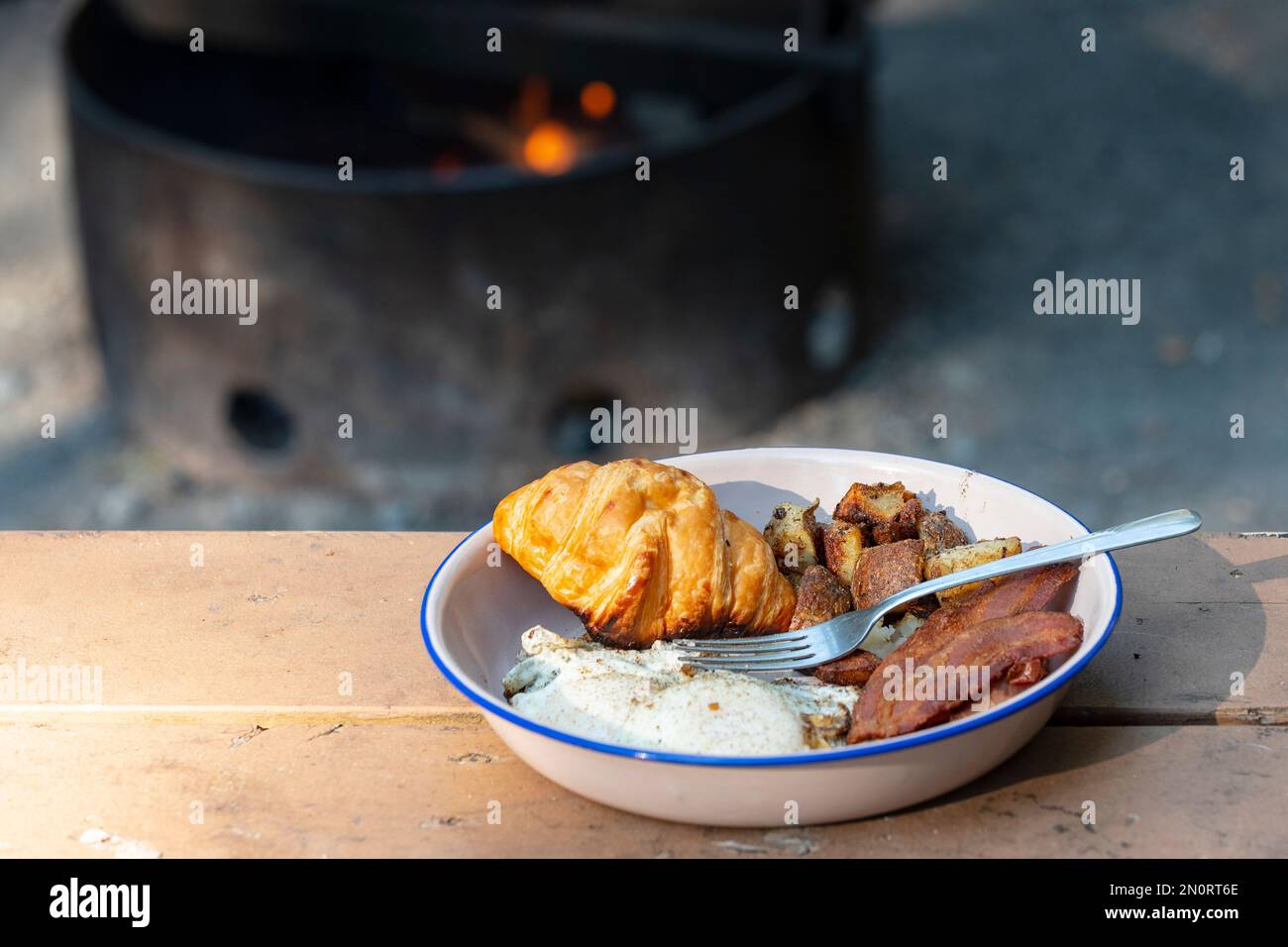 Breakfast of eggs, bacon, hashbrowns, croissant, cooked in a castiron