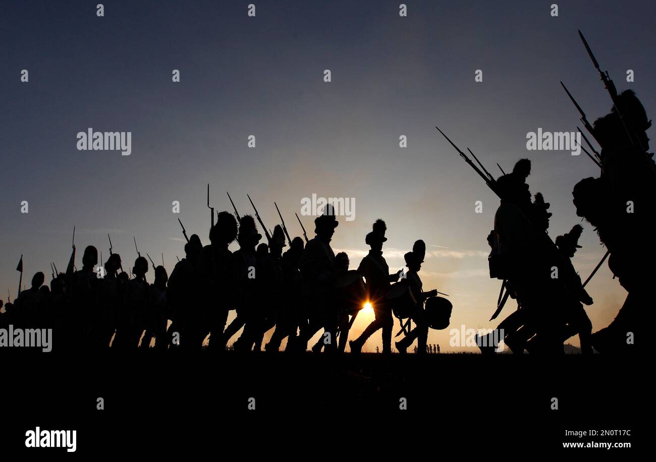 History enthusiasts dressed in regimental uniforms march during a reenactment of Napoleon's
